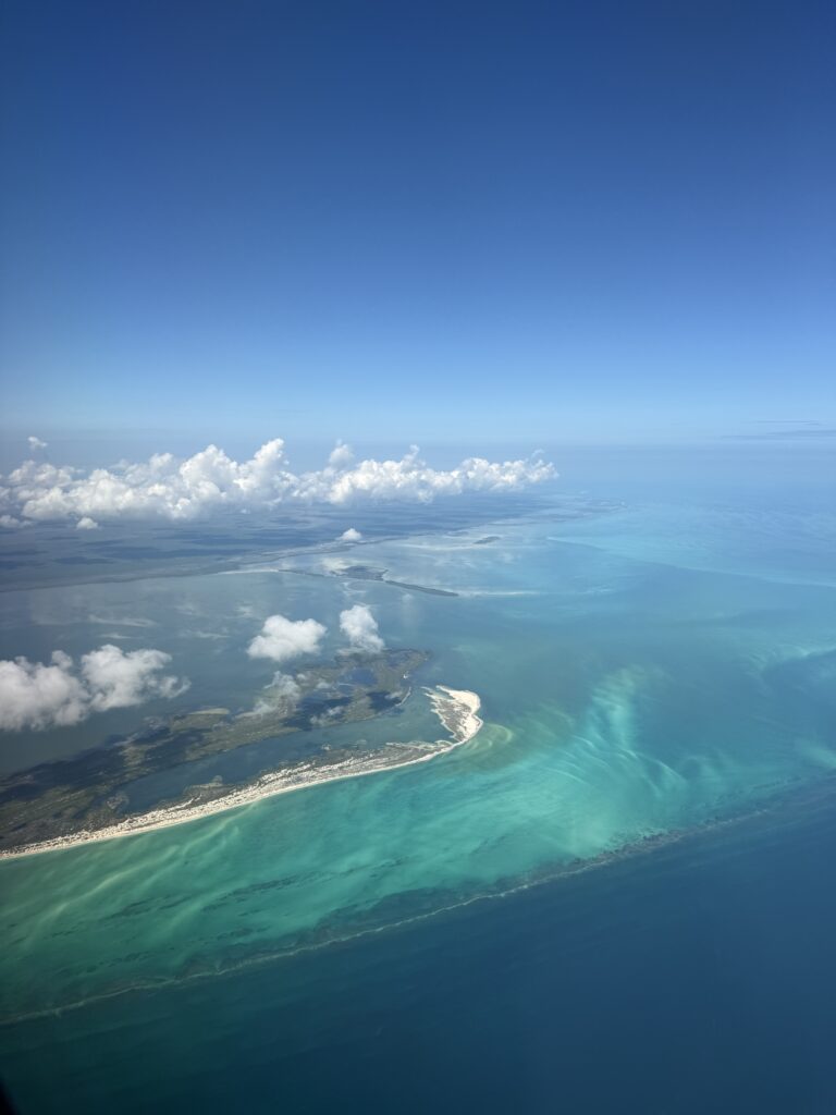 Aerial view of tropical island from airplane window - turquoise water destination for romantic travel
