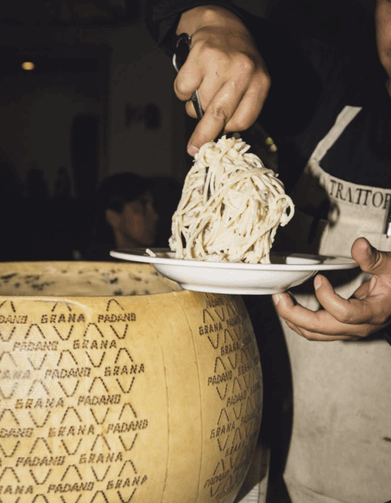 Fresh pasta being twirled from authentic Grana Padano cheese wheel at Florence trattoria - traditional Italian culinary experience and autumn food tours in Tuscany with wine and food travel specialist