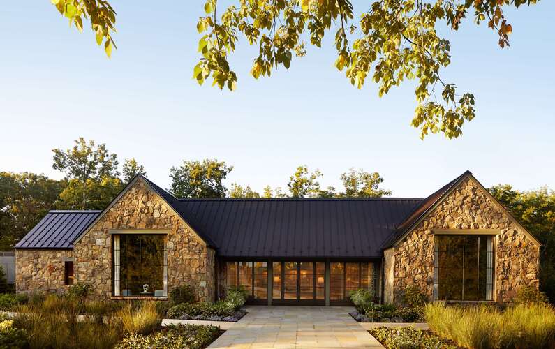 Keswick Hall spa exterior with natural stone architecture offering holistic wellness treatments in Charlottesville Virginia wine country