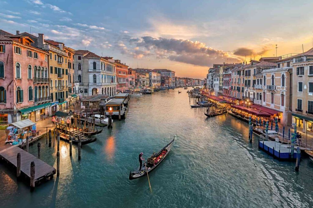 Grand Canal in Venice Italy at sunset with gondola and historic buildings