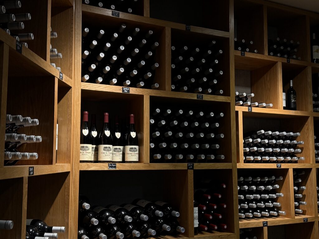 Wine library storage at Lost Mountain Vineyards with bottles aging in wooden racks.