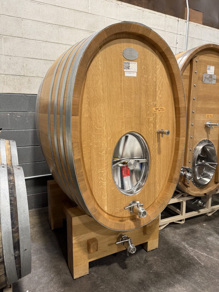 Large oak wine barrel aging wine at Common Wealth Crush winery in the Shenandoah Valley