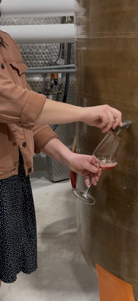 Sampling wine directly from a fermentation tank at Common Wealth Crush winery in Virginia